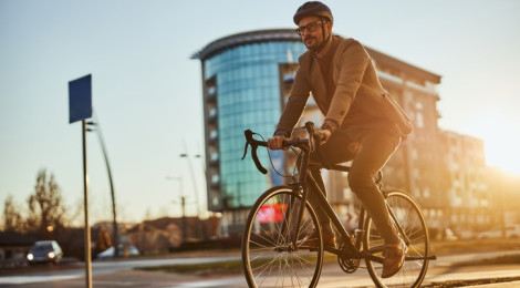 Trendy handsome businessman on city street with his bike commuting